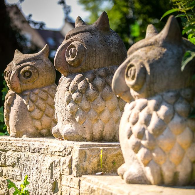 Nahaufnahme von drei Eulen-Figuren aus Stein am Liebesgrund