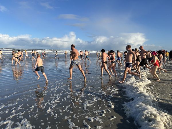 Menschen rennen in die Nordsee