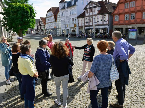 Eine Gästeführer mit einer Gruppe in der Gifhorner Altstadt.