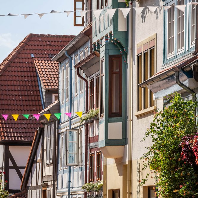 Seitenansicht auf Fachwerkhäuser mit bunten Holzbalken und Girlanden im Fachwerkviertel Hildesheim