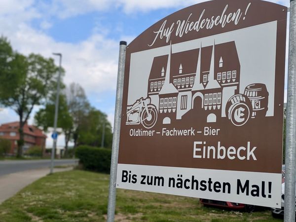 Braunes Ortsausgangsschild von Einbeck mit Symbolen für Fachwerk, Oldtimer und Bier.