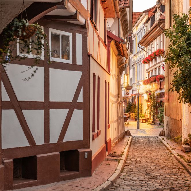 Blick auf eine schmale Gasse vom Kehrwiederturm aus mit Fachwerkhäusern im Fachwerkviertel in Hildesheim in der Abenddämmerung