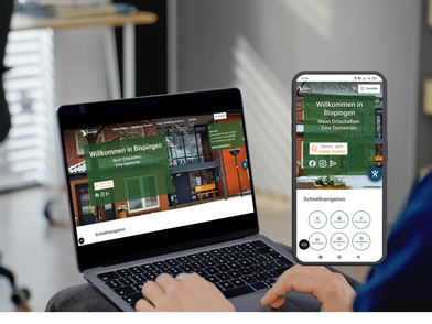 Ein Laptop und ein Smartphone zeigen die Startseite der Website der Gemeinde mit dem Titel 'Willkommen in Bispingen'. Die Website hat einen grünen Bereich mit weißer Schrift und darunter ein Bild von Gebäuden. Auf dem Smartphone ist die gleiche Website zu sehen, darunter eine Schnellnavigation mit kreisförmigen Symbolen und Texten. Im Vordergrund sind Hände zu sehen, die den Laptop bedienen. Im Hintergrund steht ein Stuhl und ein Regal mit Büchern.