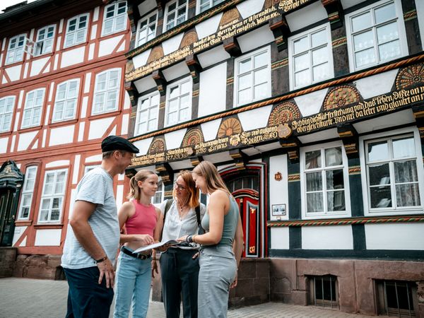 Familie vor Fachwerkhäusern Eine Familie steht vor einem Fachwerkhaus und sieht sich eine Broschüre an.