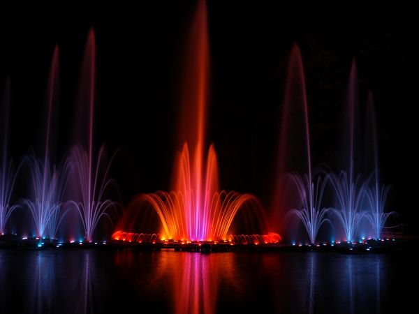 Farbig beleuchtete Fontänen in der Dunkelheit