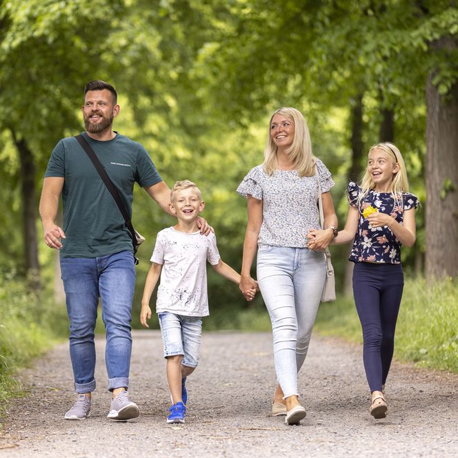 Zu sehen ist eine vierköpfige Familie beim Spaziergang auf den Hildesheimer Wallanlagen.