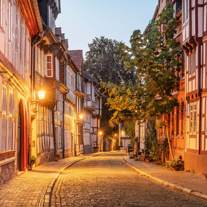 Blick in eine Straße im Fachwerkviertel Hildesheim mit historischen Fachwerkhäusern und bunten Fassaden in der Abenddämmerung