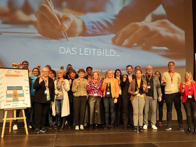 Nachhaltigkeitsleitbild aboutcities Personengruppe auf der Bühne während der Unterzeichnung des Nachhaltigkeitsleitbildes der aboutcities.