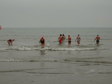 Leichtbekleidete Badegäste in der Nordsee im Winter