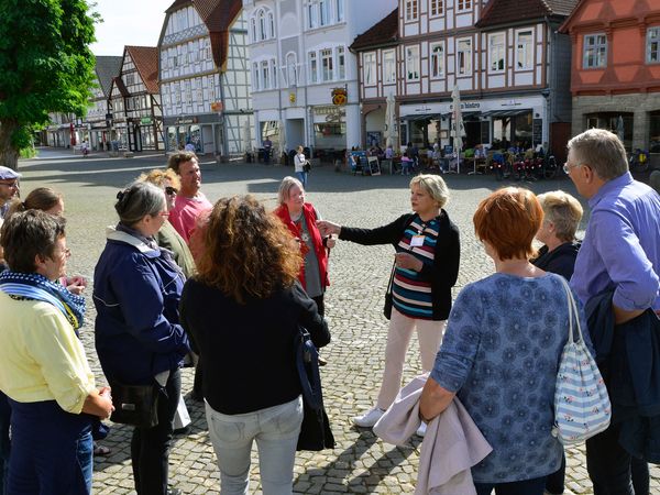 Eine Gästeführer mit einer Gruppe in der Gifhorner Altstadt.