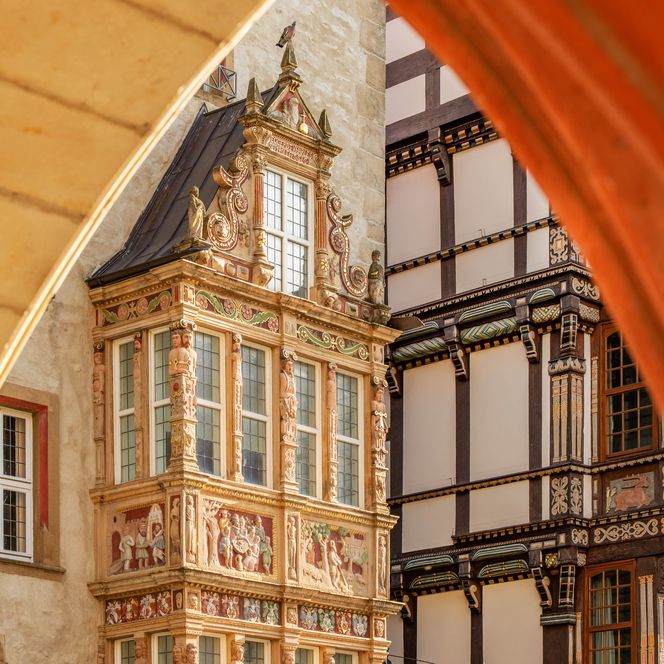 Blick auf den Renaissance-Erker am Tempelhaus am historischen Marktplatz Hildesheim durch einen Torbogen des Rathauses